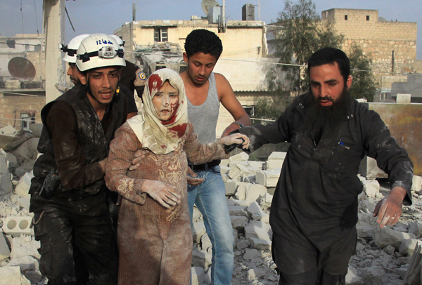 Syrian rescue workers and residents help an injured woman following a reported air strike by government forces on the  rebel-held neighbourhood of Haydariya in the northern city of Aleppo on Sunday (AFP photo)